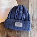 Close-up of thick cable knit texture and city label on a dark blue winter beanie hat - M (55-59cm) / Navy Blue