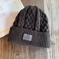 Dikke houtskoolgrijze kabelgebreide muts met fleecevoering en logo van een bergpatch - M (55-60cm) / koffiekleur