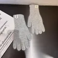 Detail von hellgrauen Strickhandschuhen mit flauschiger Textur und Handm-Etikett - Einheitsgröße / Hellgrau