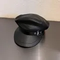 Nahaufnahme der schwarzen PU-Leder-Schirmmütze mit Litschi-Struktur und Metallschnalle - M / Schwarz