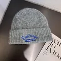 Close-up of gray ribbed knit beanie with blue letter embroidery on folded brim - M (55-59cm) / Light Gray