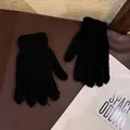 Close-up of black coral fleece gloves with elastic ribbed cuffs on a textured background - Adult / Black