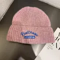Detail of pink-purple knit beanie with blue embroidered Bestchoise logo on dark background - M (55-59cm) / Pink