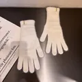 Nahaufnahme cremefarbener Strickhandschuhe mit weichem Kaninchenfell-Effekt und Etikett - Einheitsgröße / Weiß