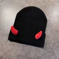 Dettaglio del berretto in maglia nera con corna da diavolo rosse e trama a costine - M / Nero