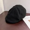 Detail of classic black wool beret hat showing thick fabric texture on wooden surface - M / Black