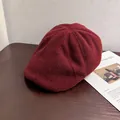 Close-up of burgundy wool newsboy cap showing rich fabric texture on wood surface - M / Burgundy