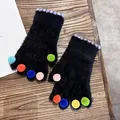 Detailansicht der flauschigen fingerlosen Handschuhe mit bunten Bommeln und Plüsch - Einheitsgröße / Schwarz