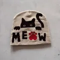 Close-up of beige knit beanie featuring cat jacquard pattern and Meow text detail - M (52-59) / Khaki