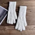 Nahaufnahme weißer Plüschhandschuhe mit langem Kunstpelz auf einer Vintage Holzoberfläche - Weiß