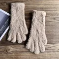 Nahaufnahme der flauschigen beige Plüsch-Winterhandschuhe auf einem rustikalen Holztisch - Khaki