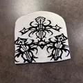 Close-up of white knit beanie featuring black gothic jacquard patterns and cross motifs - White