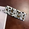 Close-up of knitted cow pattern sports headband with soft texture and tight stitching - Small Leopard Print