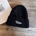 Detail of Vintage embroidery on black ribbed knit beanie placed on wood surface - M (55-59cm) / Black