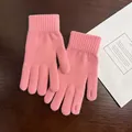 Nahaufnahme von rosa Strickhandschuhen mit gemütlichen Rippbündchen auf Holzuntergrund - Einheitsgröße / Rosa