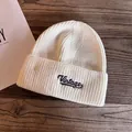 Detailed view of the Vintage embroidery patch on the beige ribbed knit beanie hat - M (55-59cm) / White