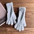 Detailaufnahme hellblauer Plüsch-Winterhandschuhe aus weichem Webpelz auf Holz - Blau