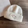 Dettaglio del ricamo a forma di cane sul caldo berretto in maglia bianco per donna - M (55-59cm) / Bianco