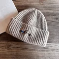 Detail of dachshund embroidery on khaki ribbed knit beanie over a wooden table - M (55-59cm) / Khaki