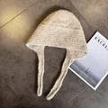 Detailed knit texture of beige balaclava hat with tie strings on a stone floor - M (55-59cm) / Beige