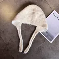 Detail of beige knit balaclava hat with long straps on a grey textured background - M (55-59cm) / White