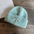 Dettaglio di un berretto in maglia a coste verde menta con ricamo di un cucciolo - M (55-59cm) / Verde menta