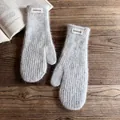 Close-up of grey plush mittens with Fashion label on a rustic wooden background - One Size / Light Gray