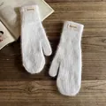 Detailed macro of white plush mittens with a FASHION label on rustic wood - One Size / White