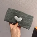Detail showing grey knitted headband with white heart embroidery and soft texture - Gray