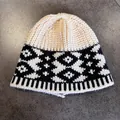 Close-up of vintage knit beanie with geometric jacquard pattern and thick texture - White