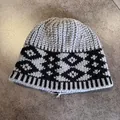 Close-up of retro knit jacquard beanie showing thick ribbed texture and geometric patterns - Gray