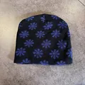 Close-up of soft black knitted beanie with vibrant blue floral patterns for winter - Black and Blue