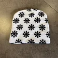 Detailed top view of a white knitted beanie featuring black floral patterns and soft texture - Black and White