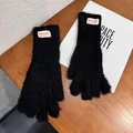 Primer plano de guantes de punto negros en felpa suave con etiqueta de marca tejida - Talla única / Dedo Completo / Negro