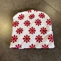 Close-up of a white knitted beanie featuring a red floral pattern and thick ribbing texture - White Red
