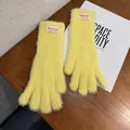 Detalle de guantes de felpa amarillos con textura suave y etiqueta tejida en la muñeca - Talla única / Dedo Completo / Amarillo