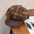 Detail von kariertem Wollstoff und brauner Lederkrempe an der Vintage Schirmmütze - M / Kaffee Kariert
