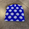 Detail of blue knitted beanie with white snowflake patterns and soft woven texture - Sapphire Blue