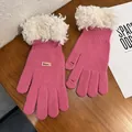 Close-up of pink knit gloves with white faux fur trim and touch screen finger openings - Rose Red