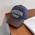 Detalle de gorra vintage de lona azul marino con bordado Capricorn y visera marrón - Ajustable / Azul marino