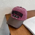 Detalle de gorra de béisbol vintage con bordado Capricorn en fondo de madera - Ajustable / Burdeos