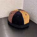 Close-up of the vintage patchwork corduroy fabric texture on a multi-color miki hat - Brimless Docker Cap / Navy Brown Yellow Patchwork