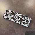 Dettaglio della fascia in maglia con motivo a mucca che mostra la trama e la qualità - Piccola stampa leopardata