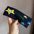 Nahaufnahme eines marineblauen Strick-Stirnbands mit bunten Sternen und elastischer Textur - Marineblau
