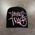 Dettaglio del berretto in maglia nero con scritte graffiti rosa su sfondo di pietra - M (52-59) / Nero Rosa