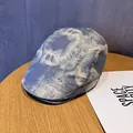 Detailopname van een blauw-witte tie-dye pet op een houten tafel met zacht licht - M (55-59cm) / Tie Dye Blauw