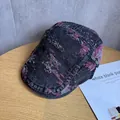 Detail der Vintage Schiebermütze aus Denim mit abstraktem violettem Jacquard-Muster - M / Schwarz