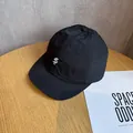 Macro detail van nylon baseballpet met korte rand en wit geborduurd dollarteken logo - Verstelbaar / Zwart