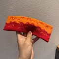 Dettaglio di una fascia sportiva in maglia arancione e rosso scuro con motivo a onde - Blocco di Colore Arancione e Rosso