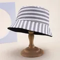 Detalle de un sombrero de pescador de rayas grises que muestra la textura y el forro - Gris